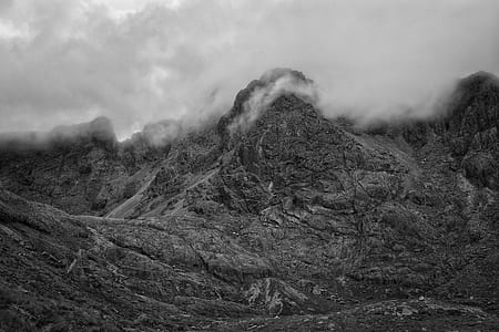 grayscale photo of mountain surrounded by fogs thumbnail