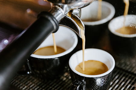 coffee being poured on four teacups thumbnail