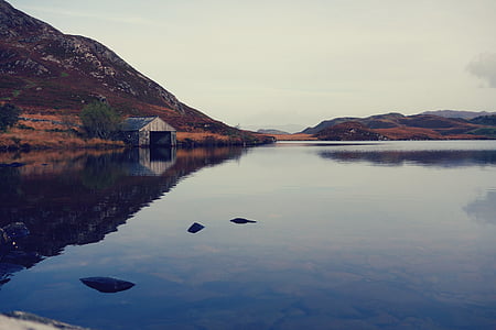 gray wooden house near body of river thumbnail