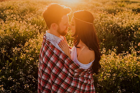 man and woman standing in front of bushes thumbnail