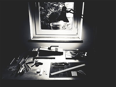 grayscale photo of table with assorted tools near window thumbnail