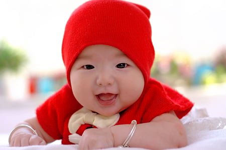 baby wearing red top and knit cap thumbnail