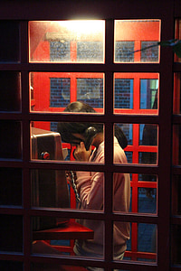 woman holding telephone in booth thumbnail