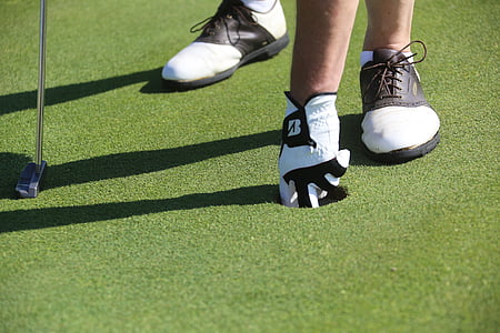 person picking ball from hole thumbnail