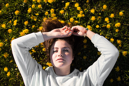 woman wearing gray long-sleeved shirt lying on yellow petal flower field thumbnail