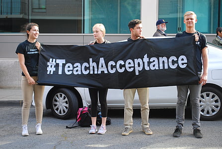 four person holding black banner with #TeachAcceptance print thumbnail
