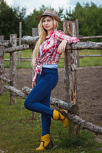 woman standing with left arm resting on wooden fence thumbnail