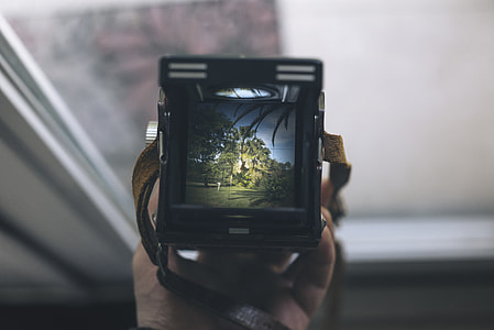 person holding black camera turned on thumbnail