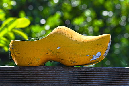 yellow wooden clog on grey wooden plank thumbnail