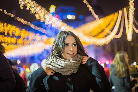 shallow focus photography of woman in black winter jacket wearing gray scarf thumbnail
