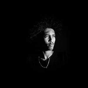 grayscale photography of man in dark background thumbnail