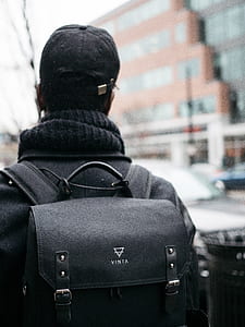 person standing beside black trash bin thumbnail