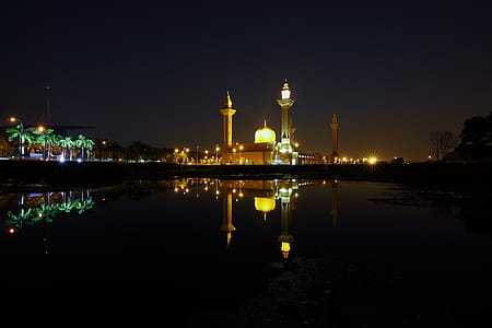 Reflection of Yellow High Rise Tower during Night Time thumbnail