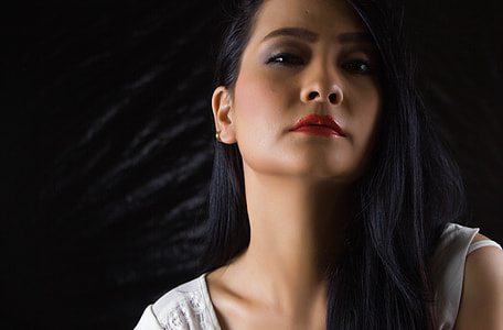 Woman in white sleeveless shirt with black background thumbnail