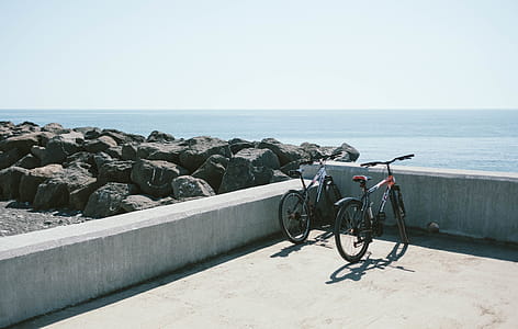 Two Bicycles Behind Gray Concrete Wall thumbnail