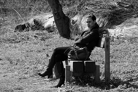 grayscale photo woman sitting on bench thumbnail