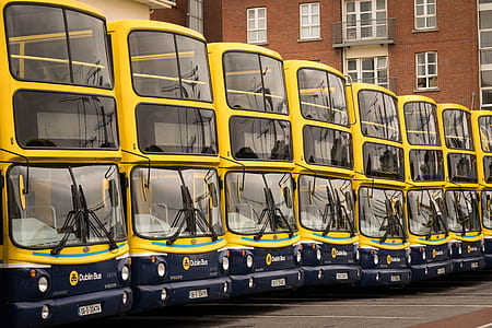 yellow buses near orange building thumbnail