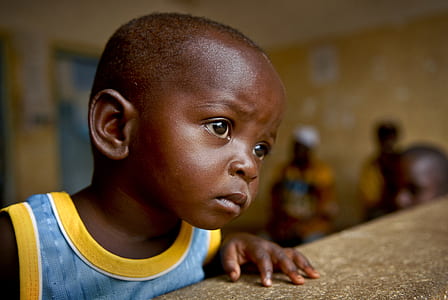 selective focus photography of boy in blue and yellow top thumbnail