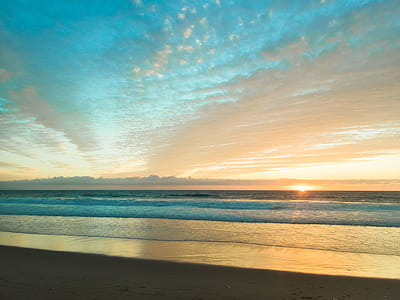 body of water under white clouds during golden hour thumbnail