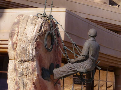 statue of man climbing up rock thumbnail