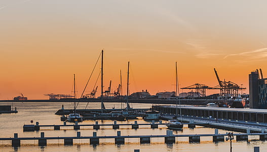 boats on body of water near dock during golden hour thumbnail