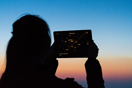 silhouette photo of woman holding iPad thumbnail