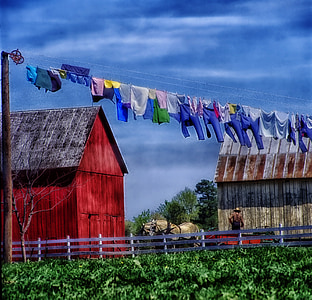 assorted-color clothes hanging on wire in daytime thumbnail