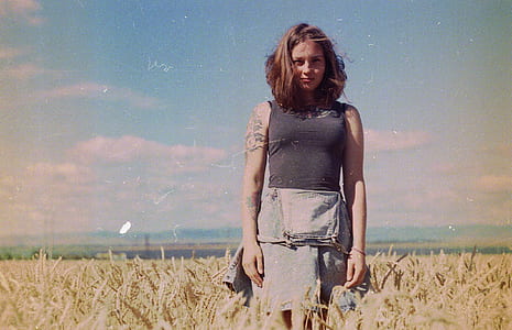 woman in black top on brown field under blue sky thumbnail