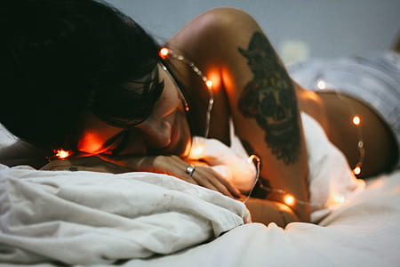 woman in topless lying on white bedspread thumbnail
