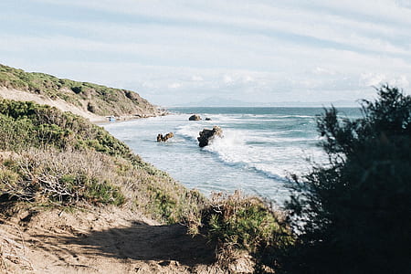 sea waves crushing boulder near cliff thumbnail