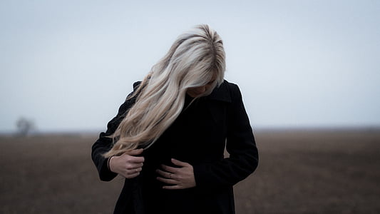 woman looking down wearing black coat thumbnail