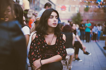 woman in black and red floral cold-shoulder top sitting on bench near woman at daytime thumbnail