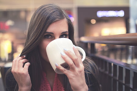 woman wearing red and black top holding mug thumbnail