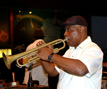 man playing brass-colored trumpet inside bar thumbnail