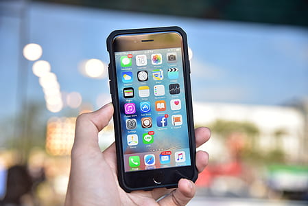 selective focus photography of person holding turned-on iPhone thumbnail