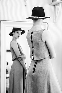 woman in black hat standing in front of mirror thumbnail