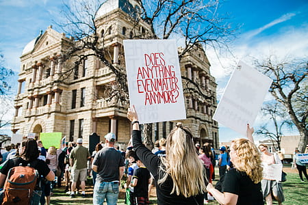 woman raising placard with does anything even matter anymore? print thumbnail