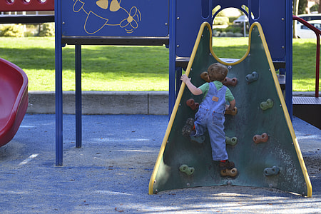 child climbing on green slide thumbnail