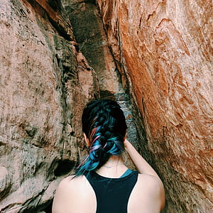 woman wearing black racer-back tank top entering rock formation thumbnail