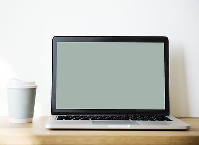 Grey and Black Laptop Beside White and Teal Coffee Cup thumbnail