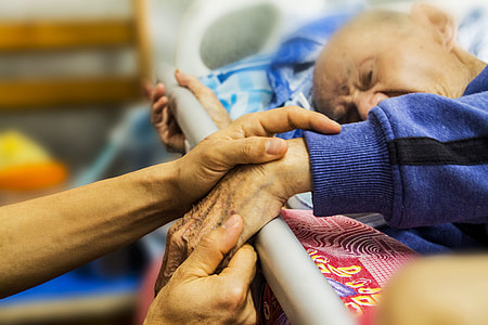 person, holding hands, man, bed, hospice, caring thumbnail