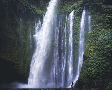 woman standing beside waterfalls at daytime thumbnail