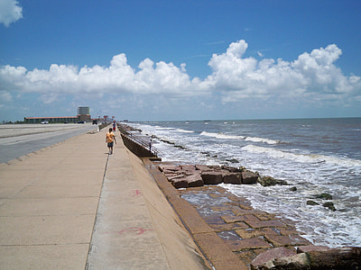 toddler walking on side of ocean bank during daytime thumbnail