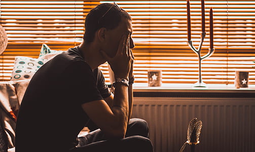 man sitting beside radiator heater thumbnail