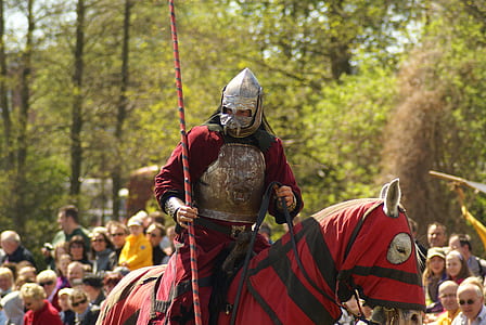 man in red and gray knight suit riding horse in red and black textile thumbnail
