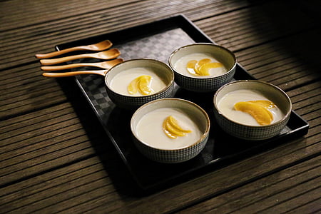 four bowls of white soups with fruit slices thumbnail