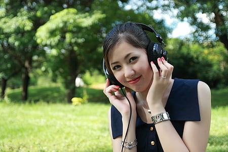 woman wearing sleeveless shirt using black headphones thumbnail