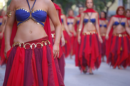 women marching outside wearing blue halter top and red skirts thumbnail