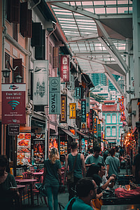 man wearing grey tank top walking beside the building thumbnail