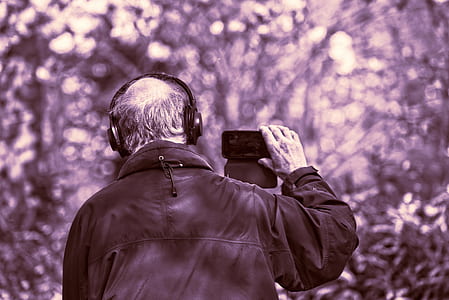 man wearing headphones and holding smartphone thumbnail